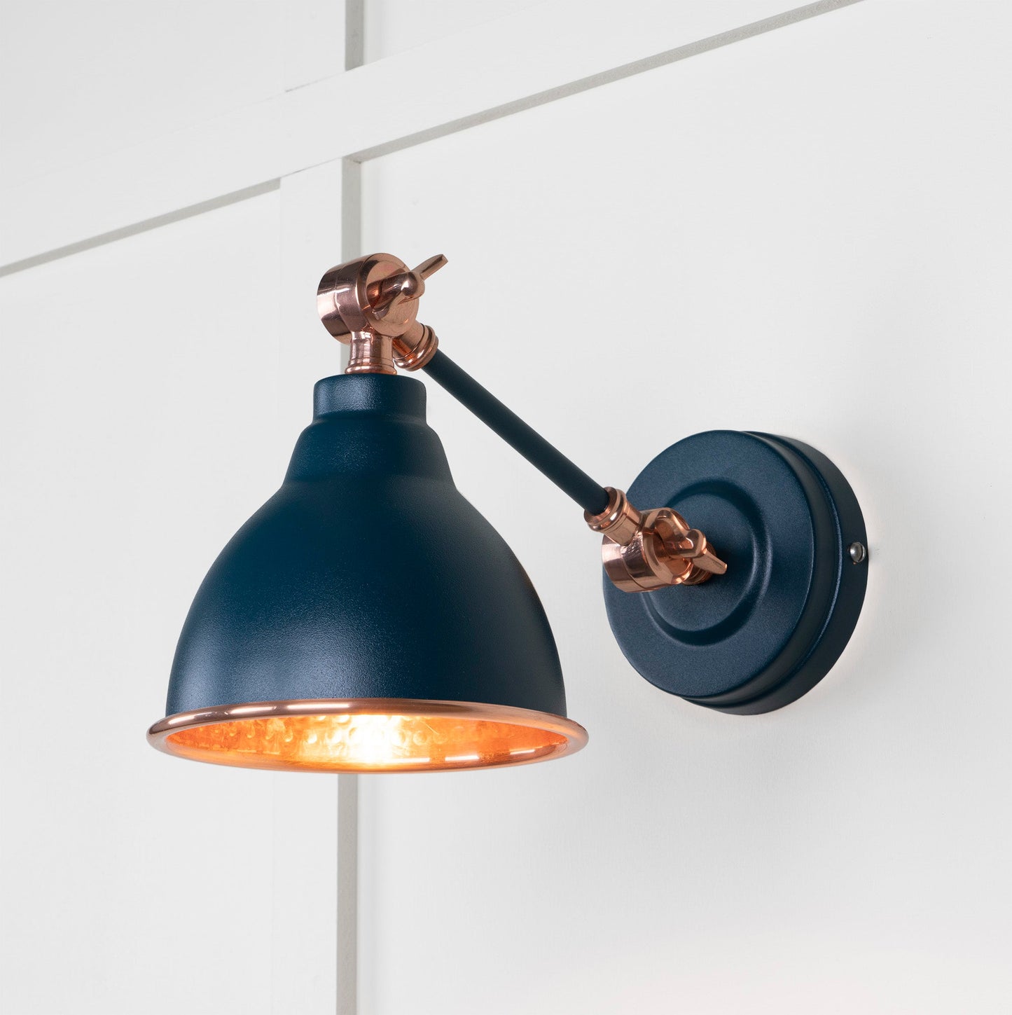 Hammered Copper Brindley Wall Light Dusk, Front Side with light on.