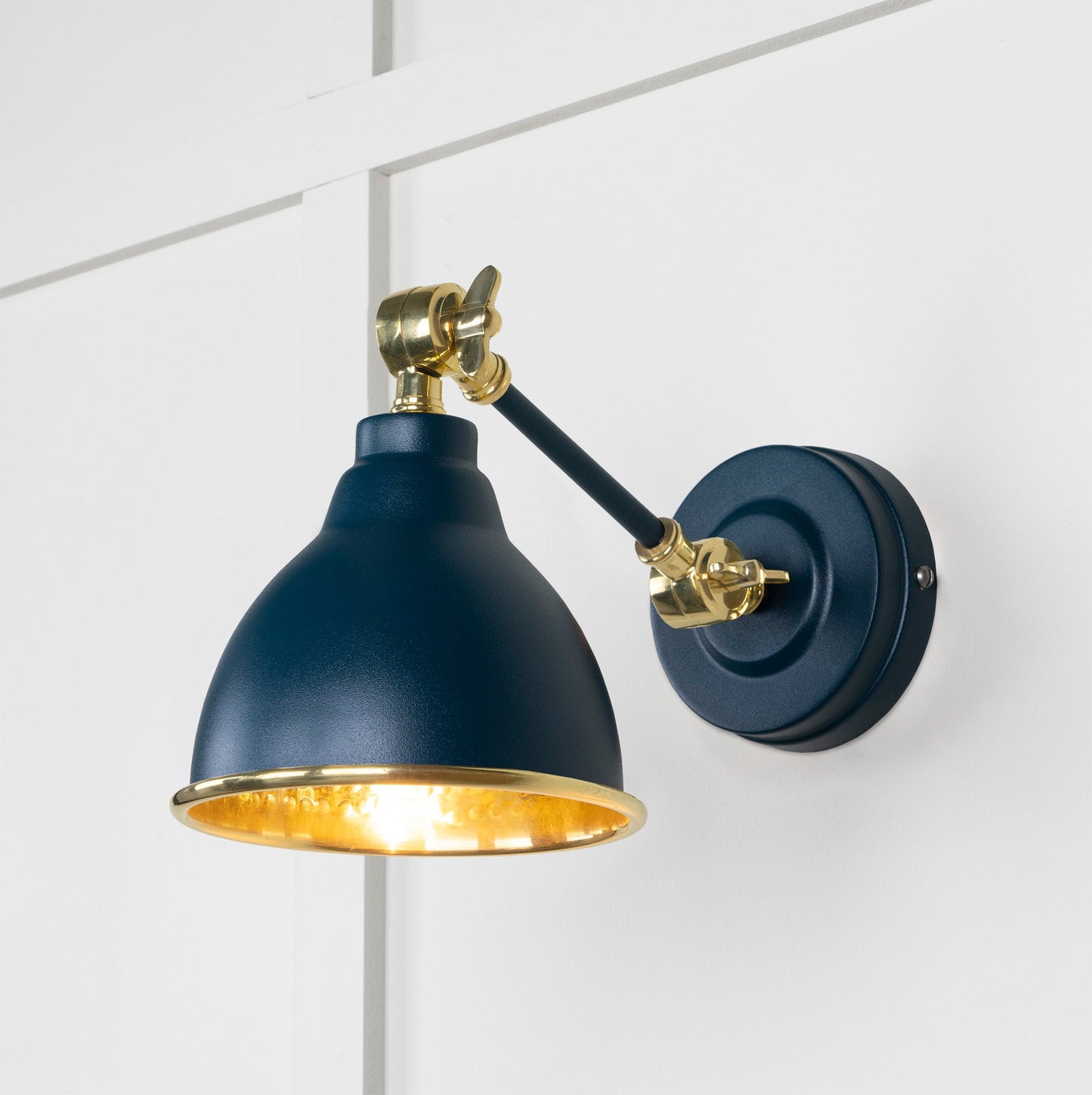 Hammered Brass Brindley Wall Light Dusk, Front Side with light on.