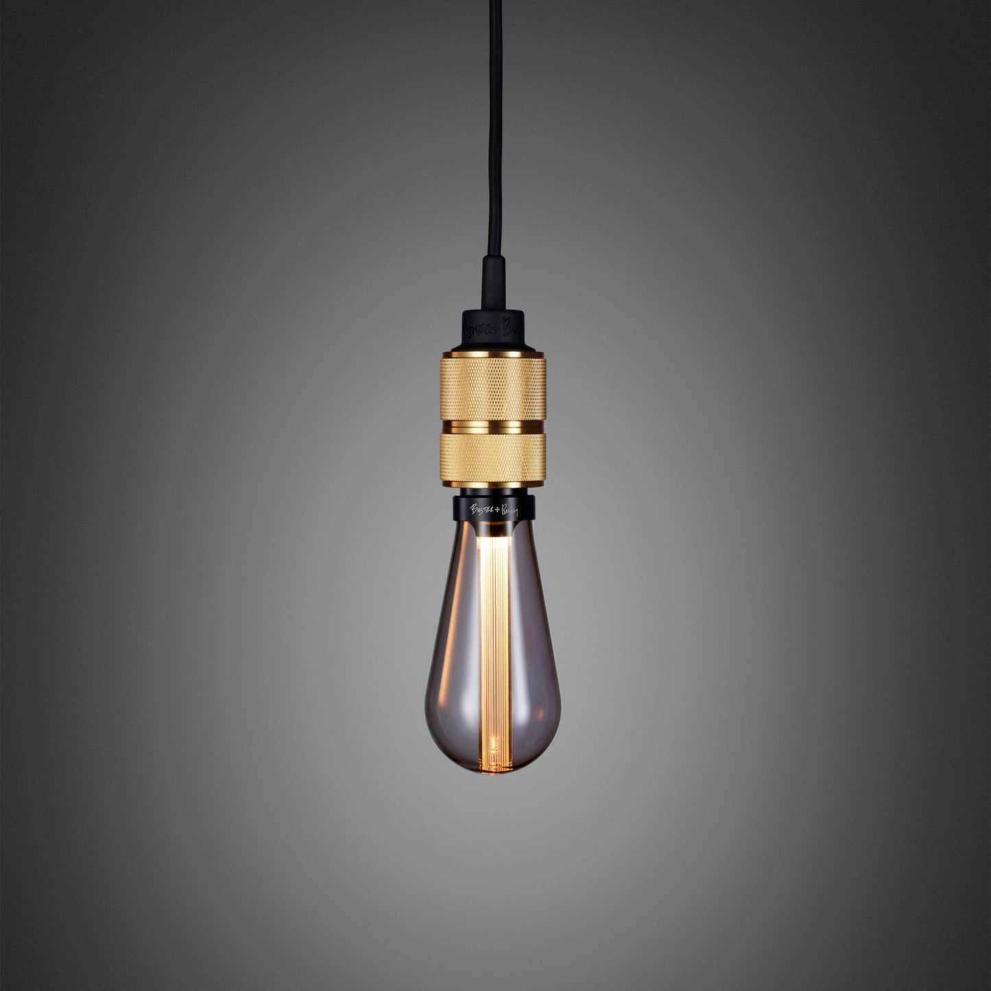 Hooked 1.0 Pendant Light / Nude Brass, close up view with smoked bulb.