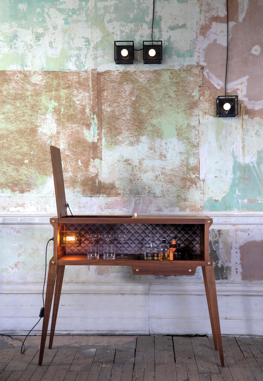 Caged Ceiling Light / Small in black marble, on wall in setting.