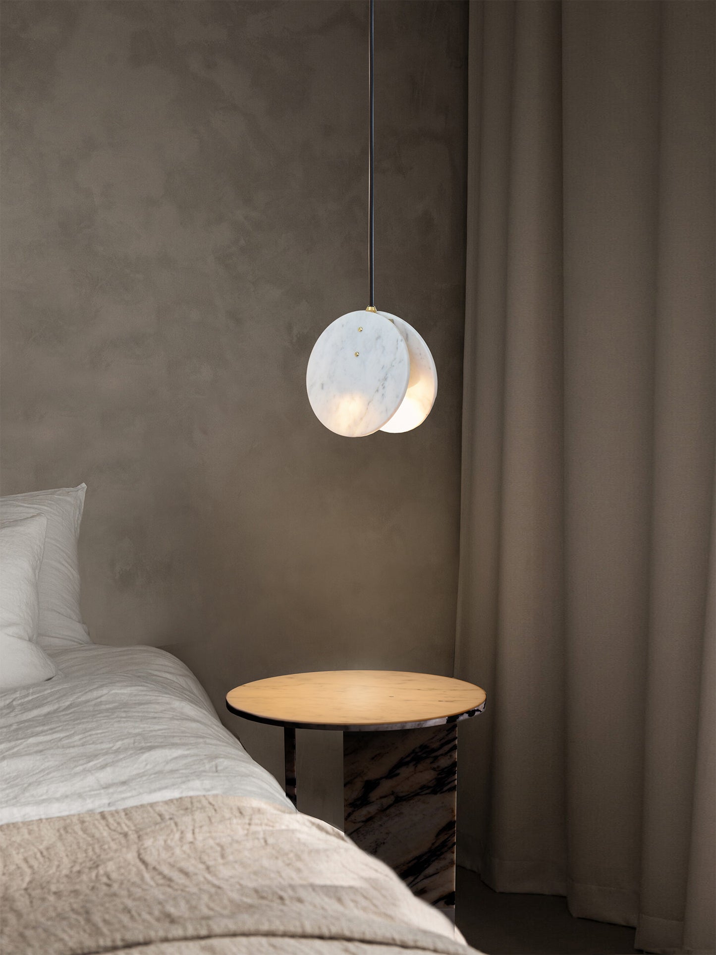 Shell Pendant Light, hanging from ceiling in setting above bedside table.
