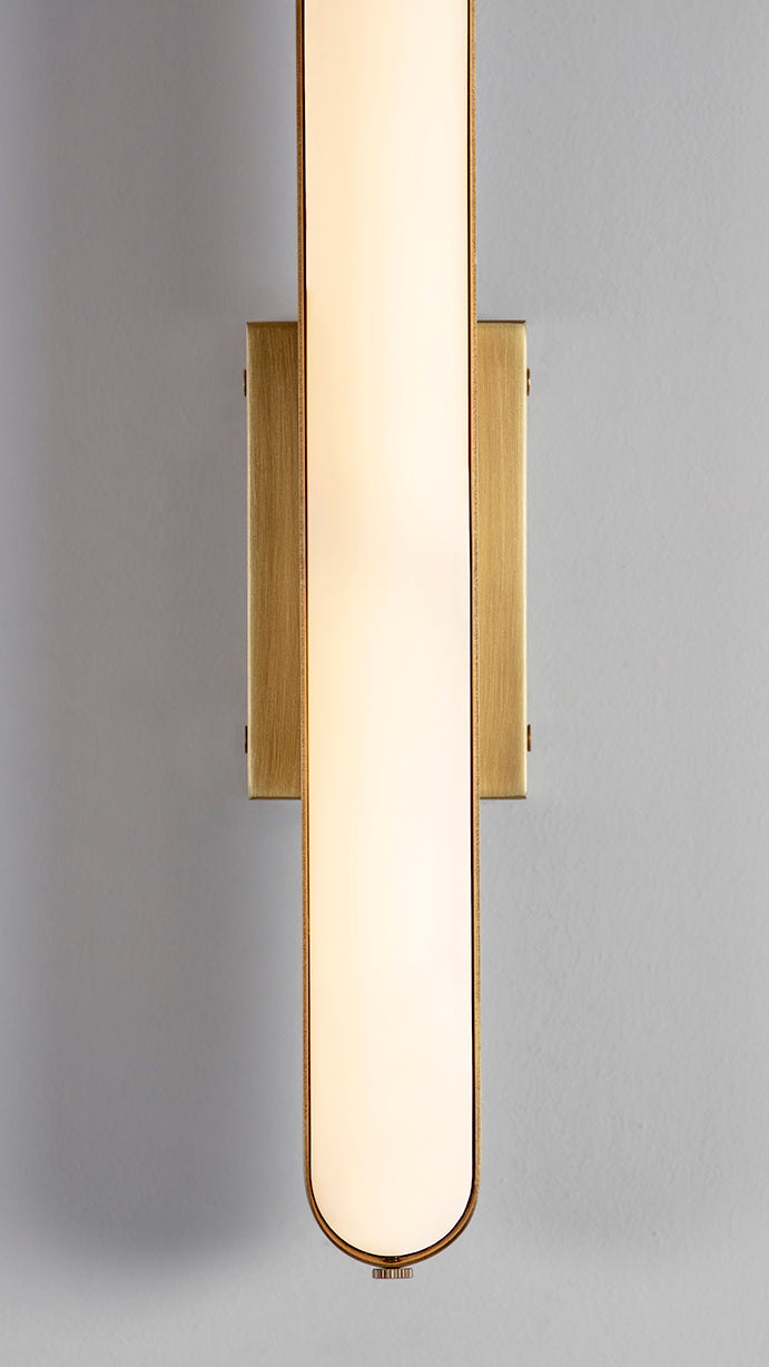 Stadium Wall Light brushed brass, detailed close of view of light on and finish.