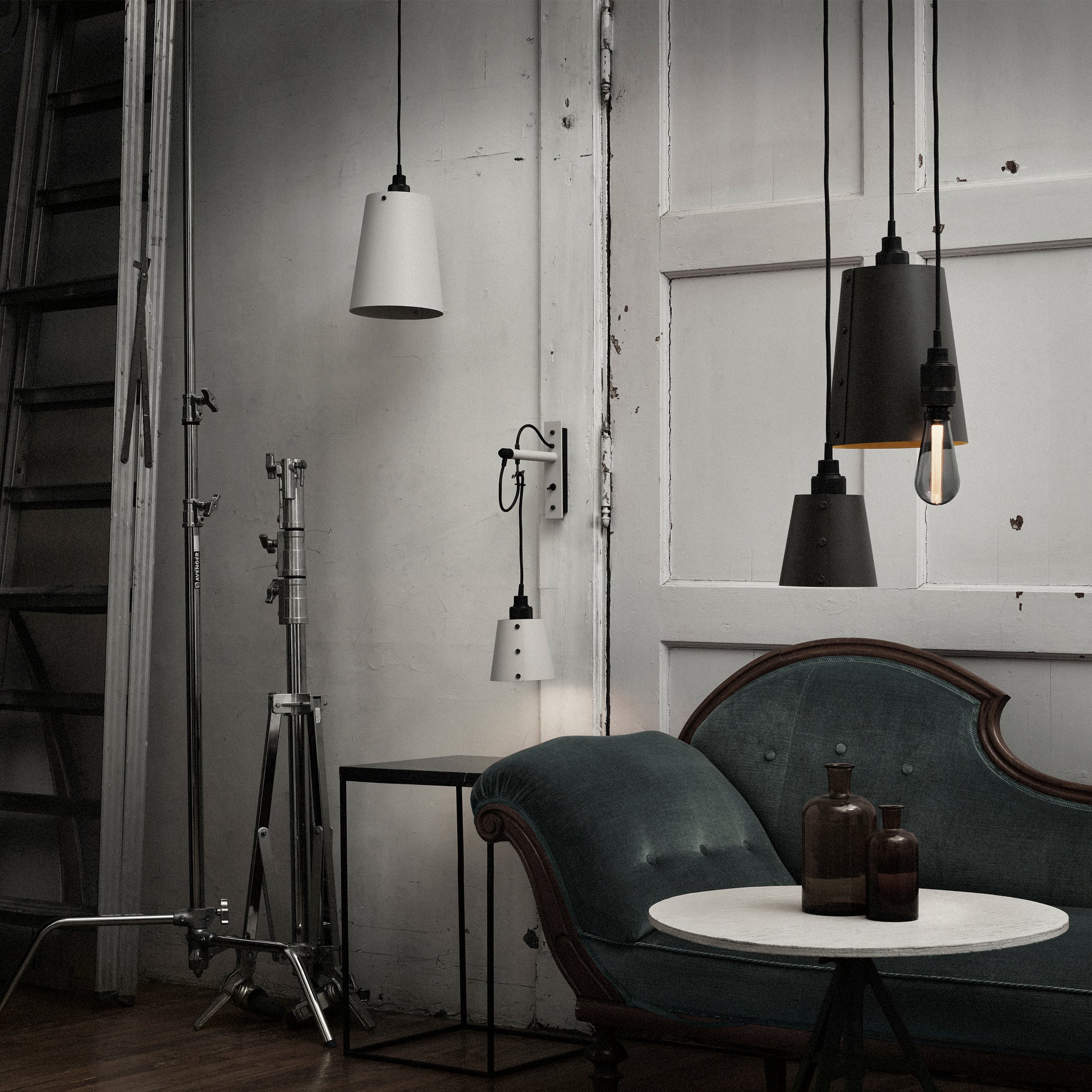 Hooked 1.0 Large Pendant Light / Stone smoked bronze, hanging from ceiling in setting with other lights.