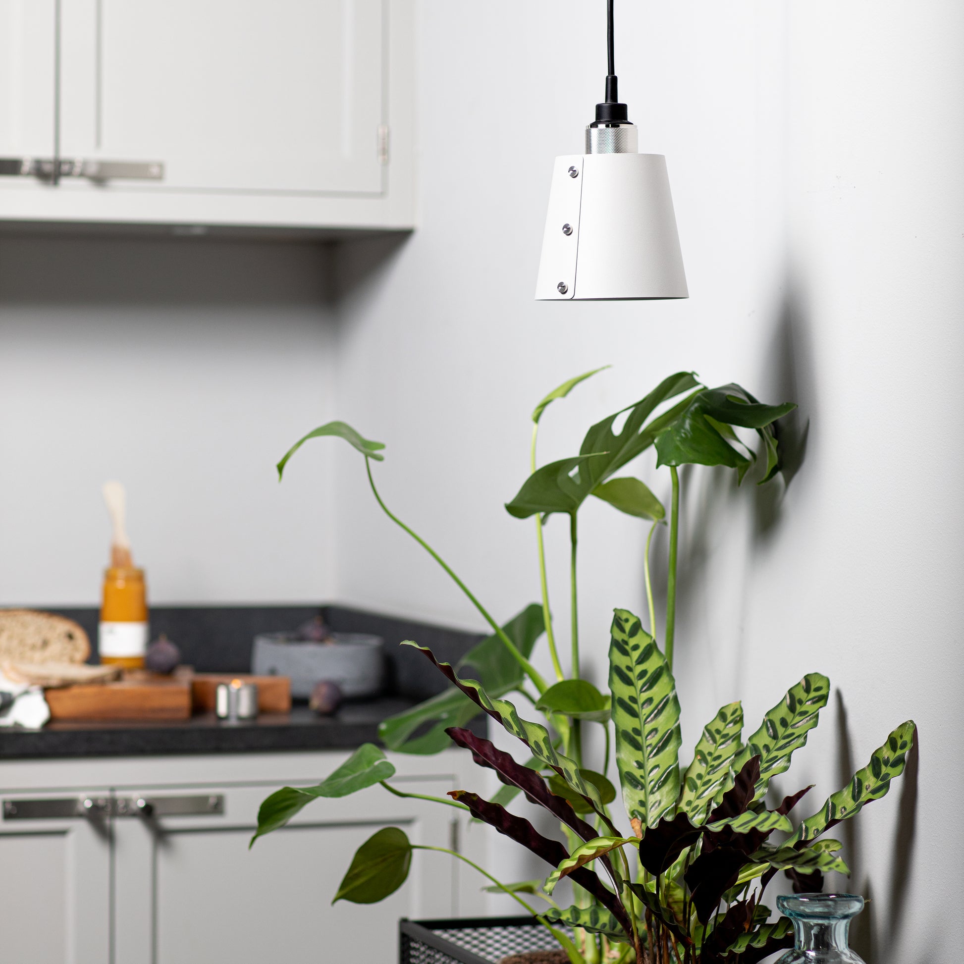 Hooked 1.0 Small Pendant Light / Stone Steel, in kitchen setting hanging from ceiling.