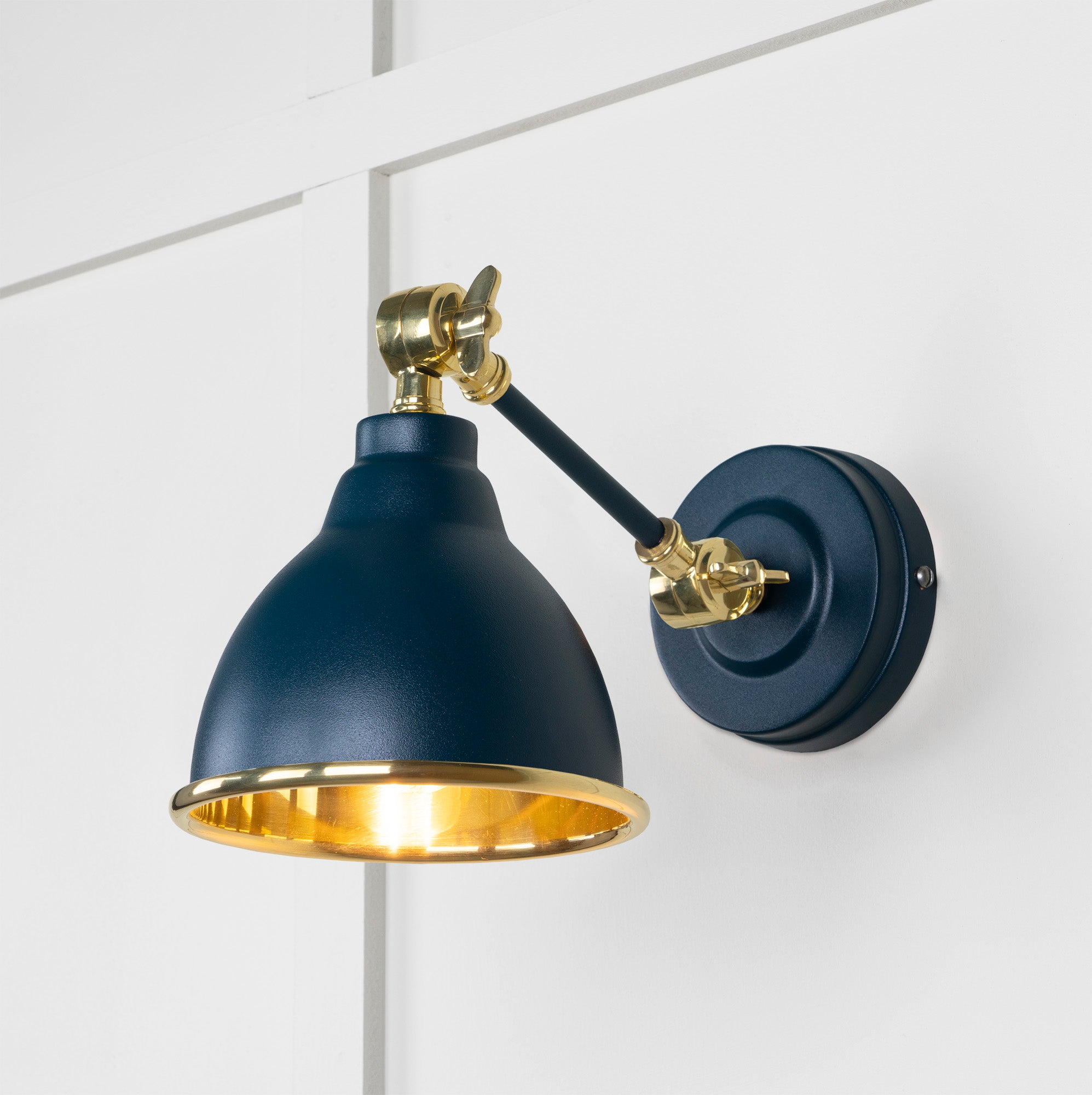 Smooth Brass Brindley Wall Light Dusk, Front Side with light on.