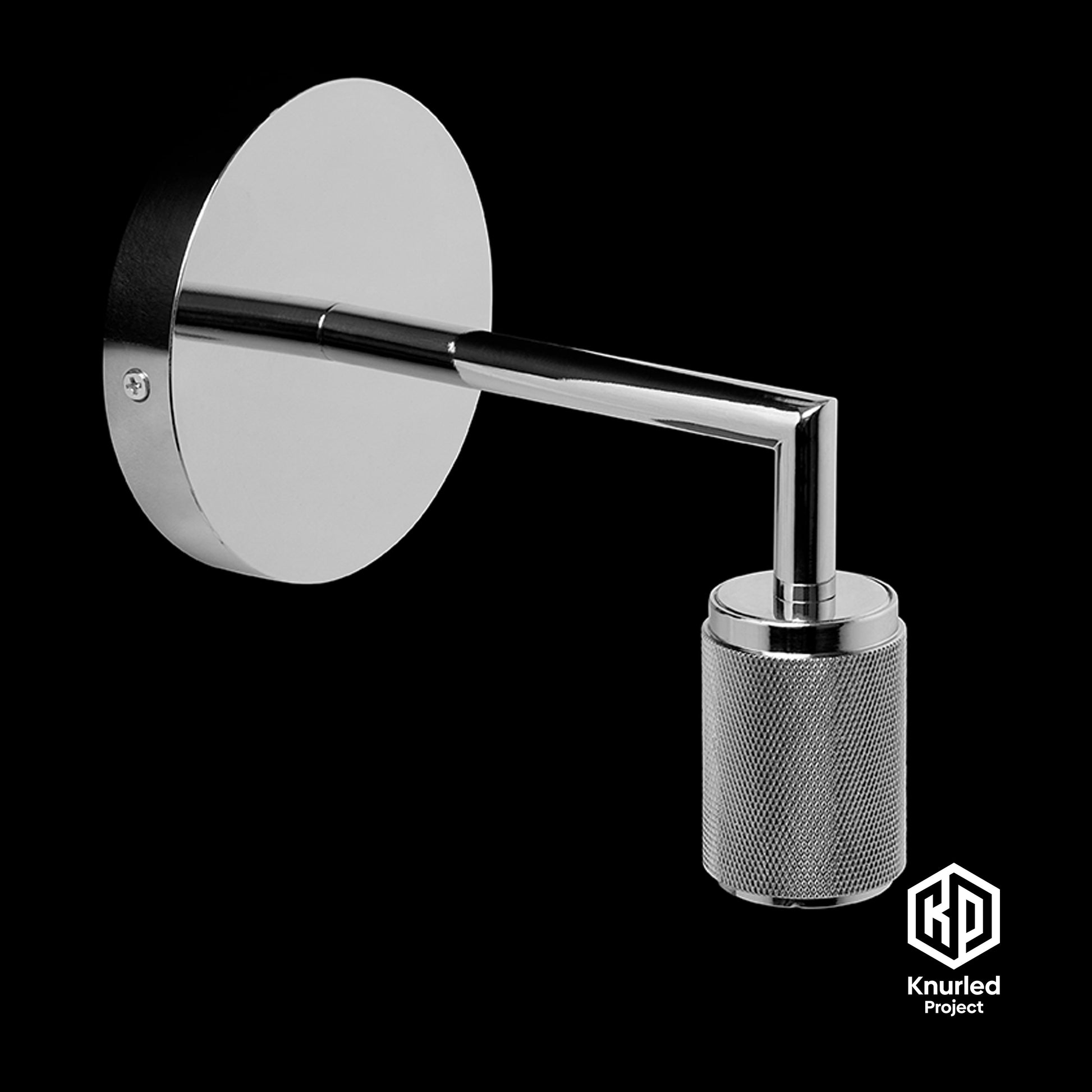 Chrome wall light at an angle on a black background