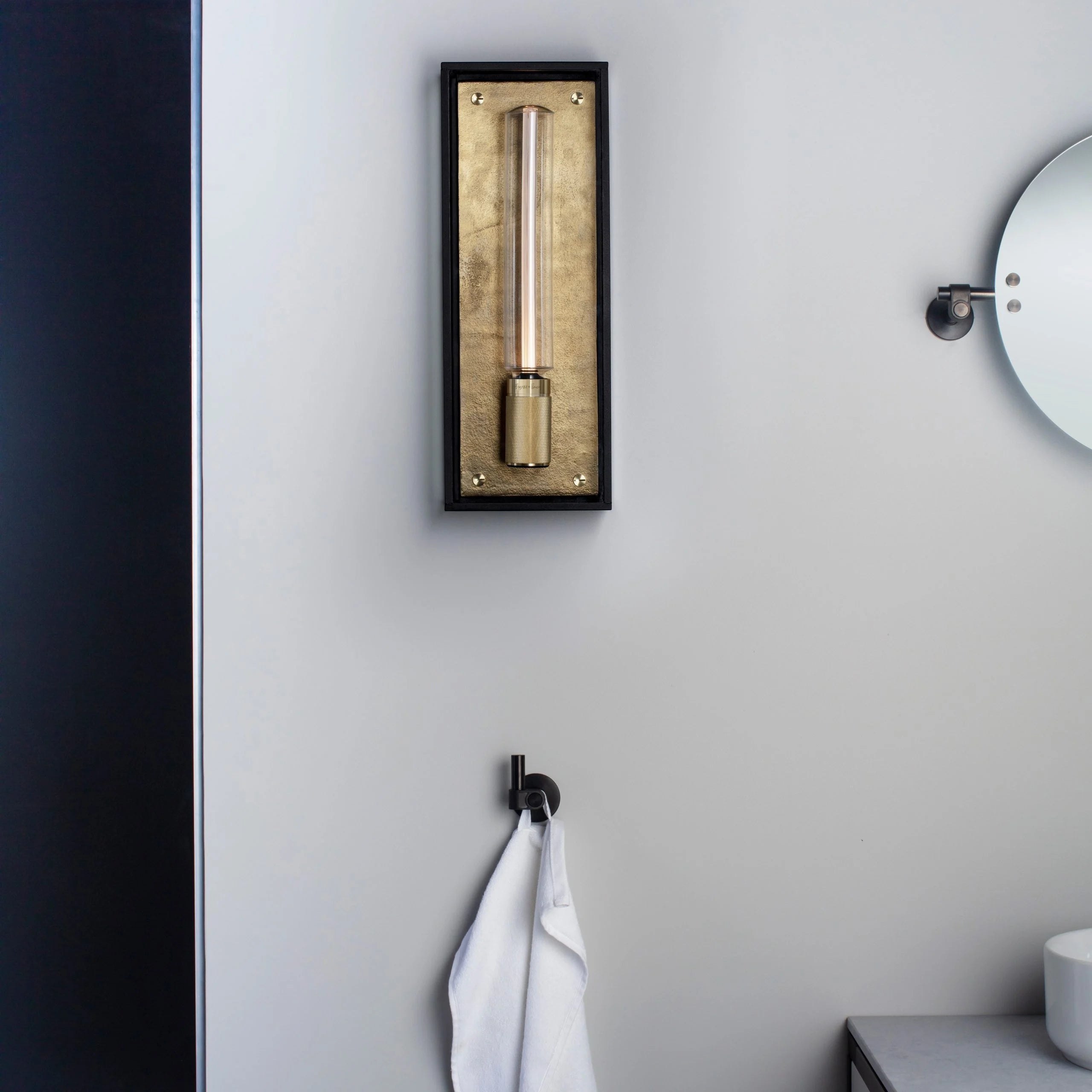 Caged Wet / Wall / Large brass, front view in bathroom setting.