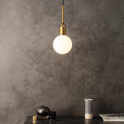 Forked pendant Light / Globe / Opal / Medium brass, front view in setting.