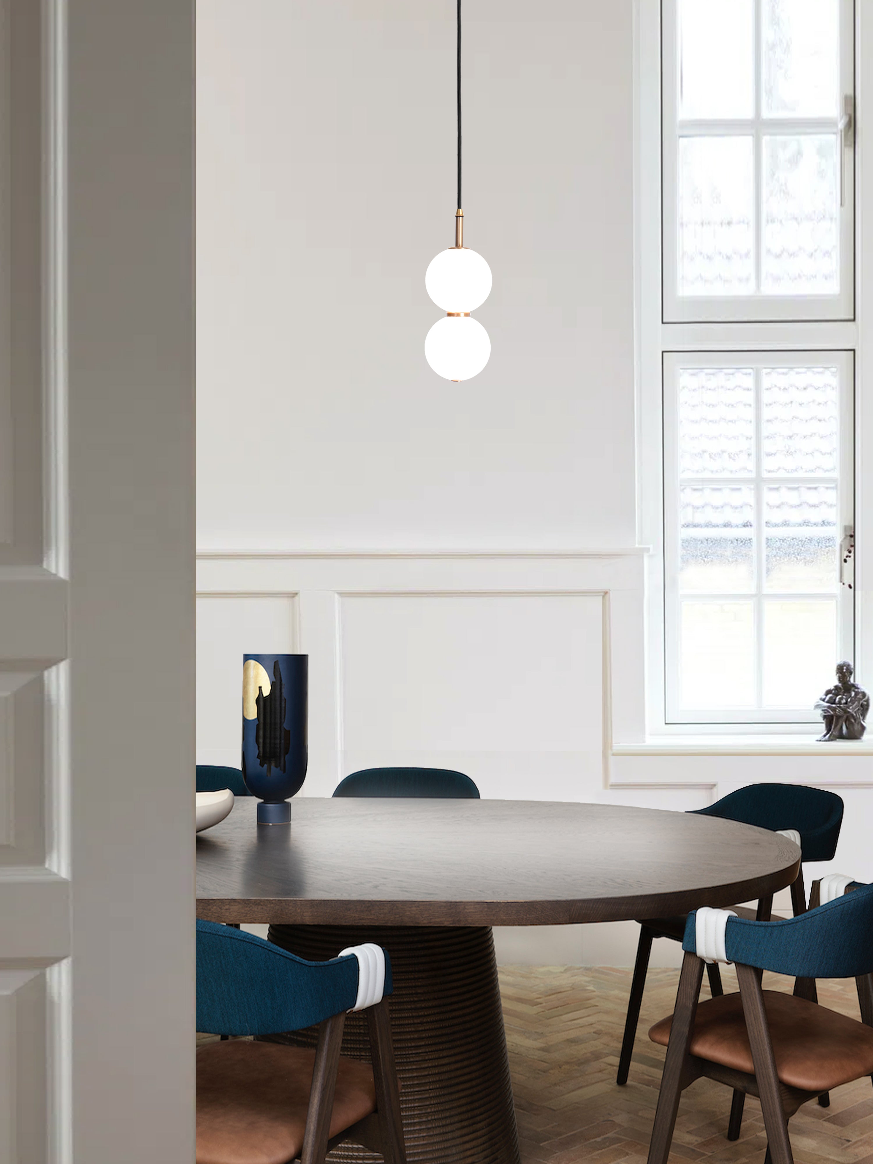 Echo Pendant Light. hanging from ceiling above table.