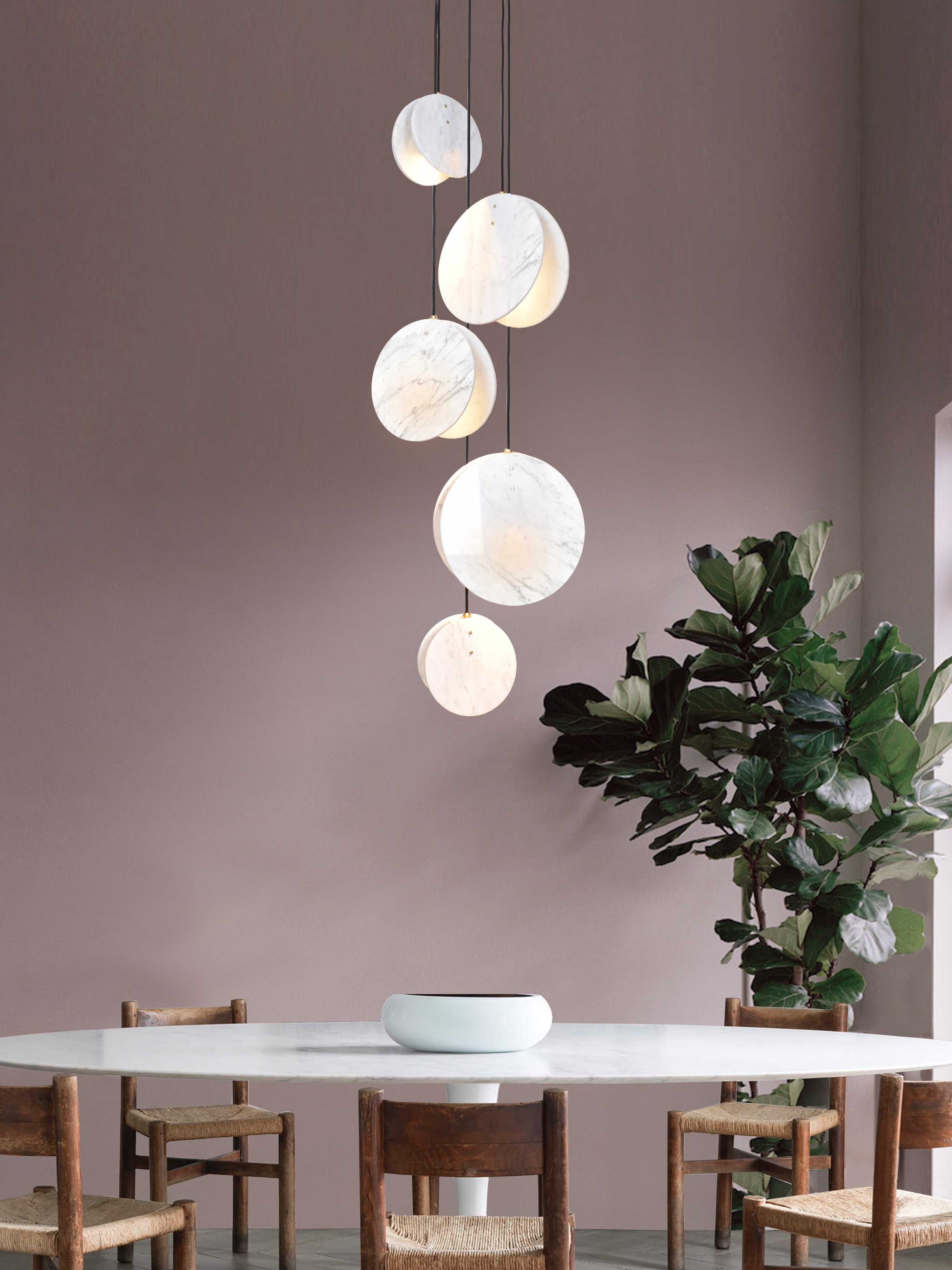 Shell 5 Light, hanging from ceiling above table in setting.