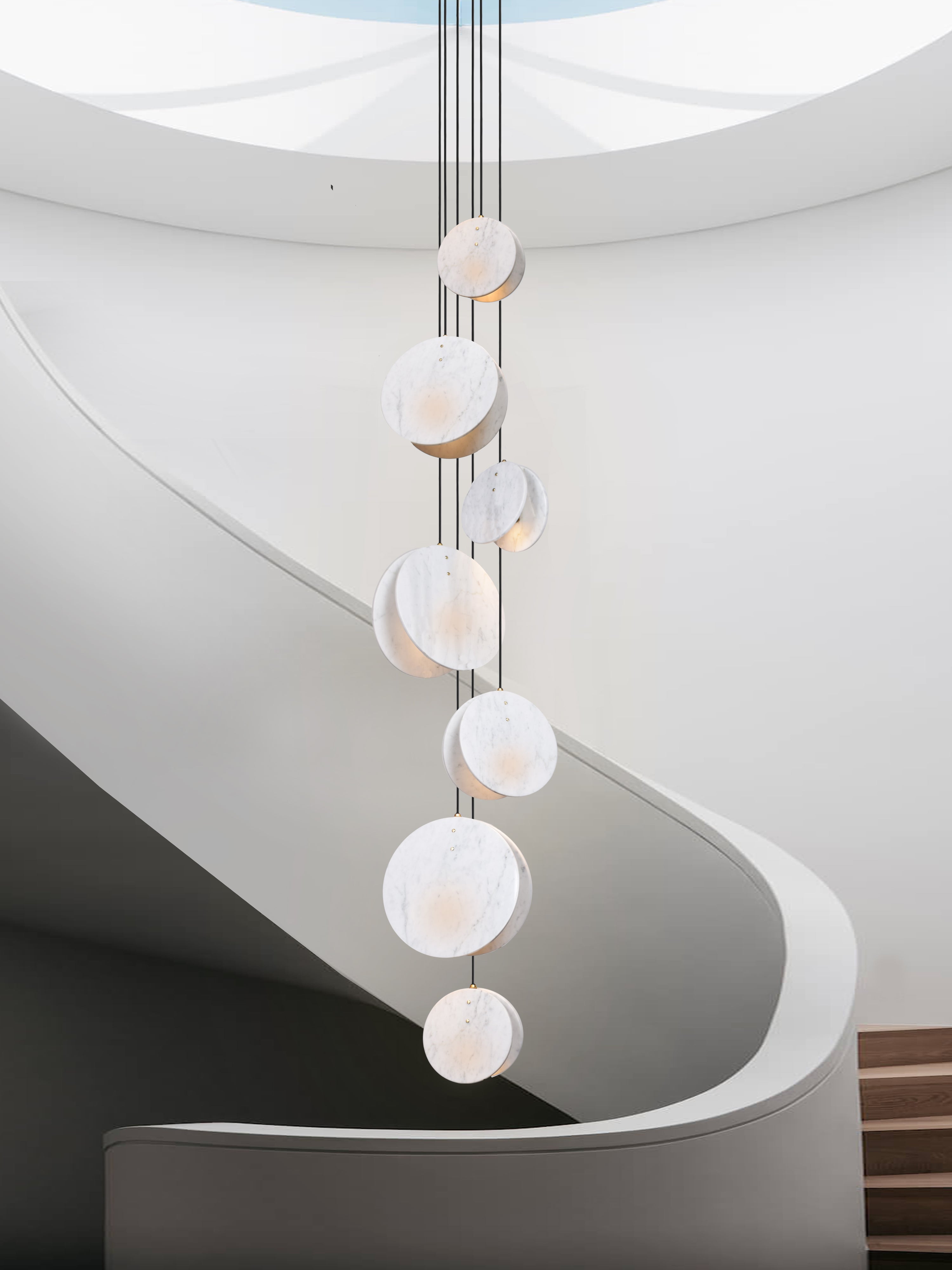 Shell 7 Light, hanging from ceiling above stairs in setting.